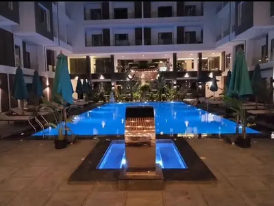 a large swimming pool in a building with blue water at 412atthepavilionimperialHurghada in Hurghada