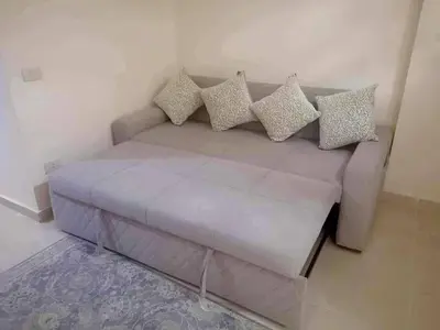 a couch with pillows on it in a room at Pearl of Tiba Golden Resort in Hurghada