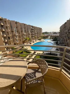 a balcony with a table and chairs and a river at Amazing View! Beach Access & Pool Hurghada in Hurghada