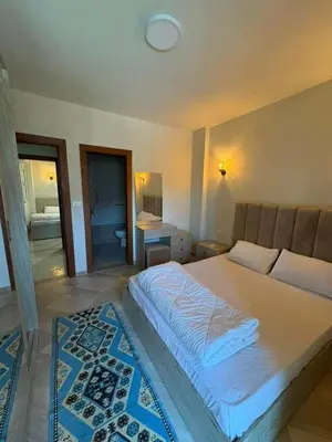 a bedroom with a large white bed with a rug at Amazing View! Beach Access & Pool Hurghada in Hurghada