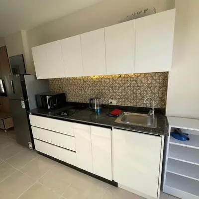 a kitchen with white cabinets and a sink and a refrigerator at Tiba Golden Resort Hurghada in Hurghada