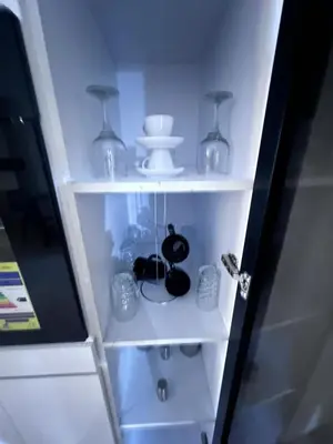 a white shelf with glass items on it at Tiba Golden Resort Hurghada in Hurghada