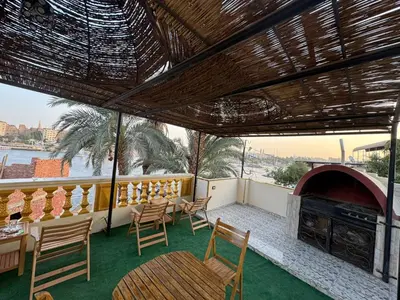 a patio with a table and chairs and a fireplace at Nubian Dreams guest house 2 in Aswan