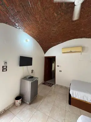 a bedroom with a bed and a flat screen tv at Nubian Dreams guest house 2 in Aswan