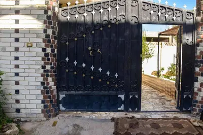 a black gate in a brick building with a doorway at golden mountain apartments in ‘Ezbet Abu Ḥabashi