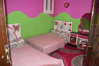 a small room with two beds and a mirror at golden mountain apartments in ‘Ezbet Abu Ḥabashi