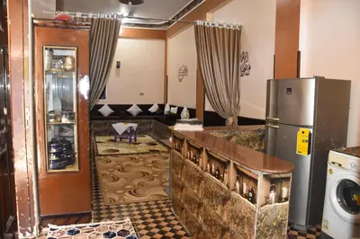 a kitchen with a refrigerator and a living room at golden mountain apartments in ‘Ezbet Abu Ḥabashi