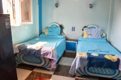 two beds in a room with blue walls at golden mountain apartments in ‘Ezbet Abu Ḥabashi