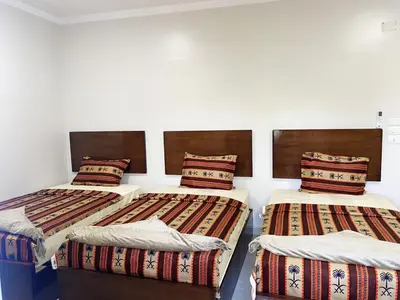 three beds in a room with white walls at nubian yellow desert in Aswan
