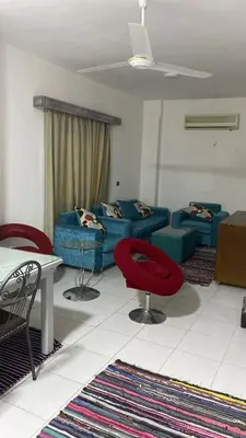 a living room with a blue couch and red chairs at الغردقة - القيادات - بالقرب من سيتي سنتر مول و شاطئ الجيش in Hurghada