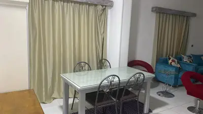 a dining table and chairs in a living room at الغردقة - القيادات - بالقرب من سيتي سنتر مول و شاطئ الجيش in Hurghada