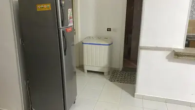 a kitchen with a refrigerator and a trash can at الغردقة - القيادات - بالقرب من سيتي سنتر مول و شاطئ الجيش in Hurghada