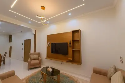a living room with a flat screen tv on a wall at Omar Apartment in Luxor