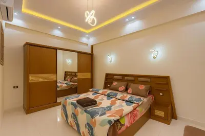a bedroom with a large bed and a mirror at Omar Apartment in Luxor