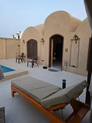a patio with a bed in the middle of a building at Lovely Private Villa in Luxor