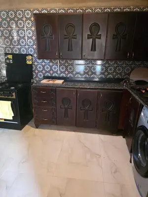 a kitchen with wooden cabinets and a stove at Lovely Private Villa in Luxor