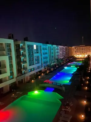 a large pool with green and blue lights at night at Fanadir bay in Hurghada