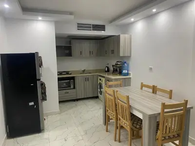a kitchen with a table and chairs and a refrigerator at Fanadir bay in Hurghada
