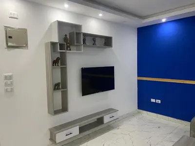 a living room with a tv and a blue wall at Fanadir bay in Hurghada