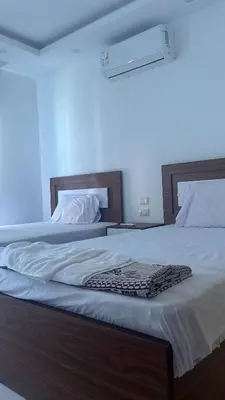 a bedroom with two beds with white sheets at Fanadir bay in Hurghada