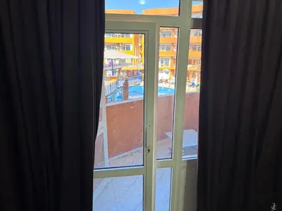 an open window with a view of a pool at شاليه اوزيس Oasis Chalet in New cairo