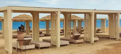 a gazebo on a sandy beach with the ocean at كومباوند البرنسيسه in Hurghada