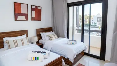 two beds in a room with a window at Ancient Sands El Gouna Hurghada in Hurghada