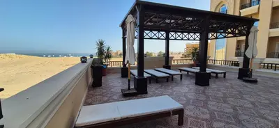 a group of benches in a pavilion next to a beach at Modern studio with sea view und large roof terrace in Hurghada