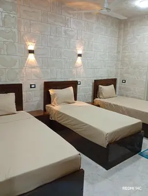 two beds in a room with lights on the wall at Sugar Nubian Guest House Nile Vew in Aswan