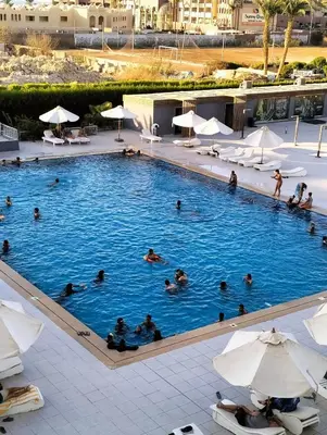 a group of people swimming in a large swimming pool at One bedroom Chalet Scandic Resort Hurghada in Hurghada