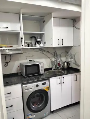 a kitchen with a washing machine and a microwave at One bedroom Chalet Scandic Resort Hurghada in Hurghada