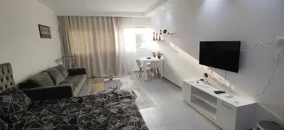 a living room with a couch and a flat screen tv at One bedroom Chalet Scandic Resort Hurghada in Hurghada