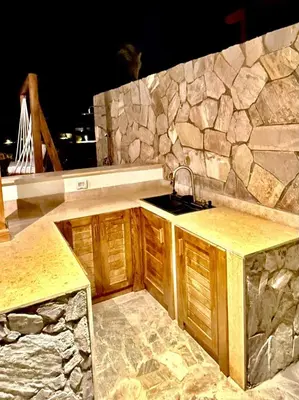 a kitchen with a sink and a stone wall at Luxury 1 BR apartment with garden, Mesca - Somabay in Hurghada