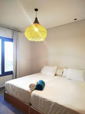 a bedroom with a large white bed under a light fixture at Luxury 1 BR apartment with garden, Mesca - Somabay in Hurghada