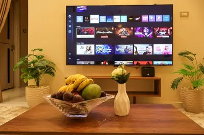 a bowl of fruit on a table with a television at Cozy Luxe Apartment in Central Aswan in Aswān