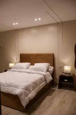a bedroom with a large bed with white sheets at Cozy Luxe Apartment in Central Aswan in Aswān