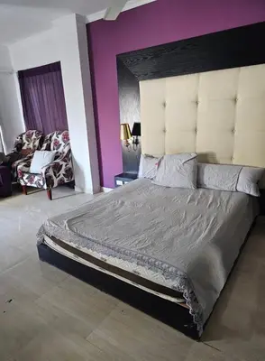 a bedroom with a large bed and a purple wall at Silkes Villa in Hurghada