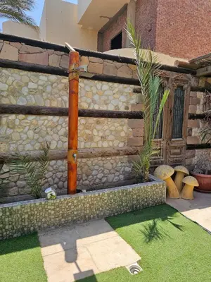 a stone wall with a water fountain in a yard at Silkes Villa in Hurghada