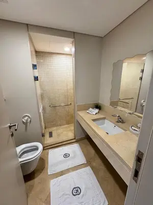 a bathroom with a toilet and a shower and a sink at Mangrove M1-5B-13 in Banī Ghālib