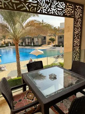 a table and chairs with a view of a swimming pool at Mangrove M1-5B-13 in Banī Ghālib