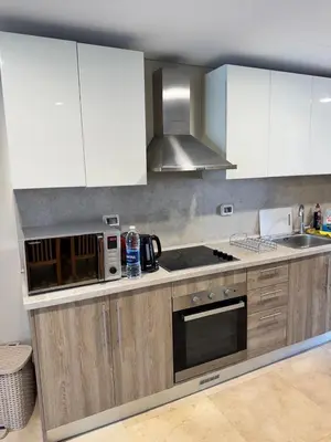 a kitchen with white cabinets and a stove top oven at Mangrove M1-5B-13 in Banī Ghālib