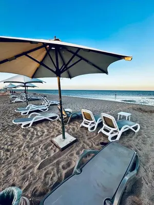 a group of chairs and an umbrella on a beach at Mangrove M1-5B-13 in Banī Ghālib