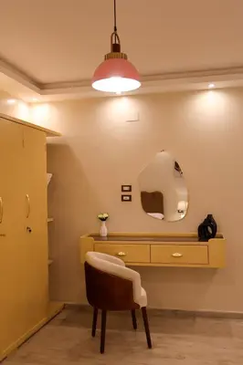 a dressing table with a chair and a mirror at Cozy Luxe Apartment in Central Aswan in Aswan
