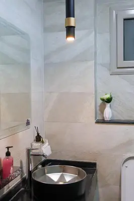a bathroom with a sink and a vase with a plant at Cozy Luxe Apartment in Central Aswan in Aswan