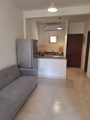 a living room with a couch and a kitchen at Makadi Heights Apartment in Hurghada