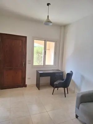 a living room with a desk and a chair at Makadi Heights Apartment in Hurghada