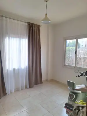 a living room with a large window with curtains at Makadi Heights Apartment in Hurghada