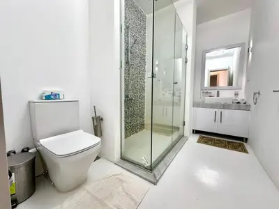 a bathroom with a toilet and a glass shower at Comfortable 3BR Apartment in Swan Lake I El Gouna Ground Floor, Garden, Terrace & Lagoon Access in Hurghada