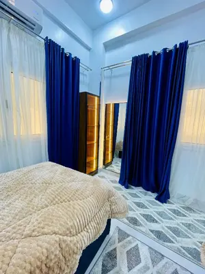 a bedroom with blue curtains and a large bed at Quiet Villa in Luxor