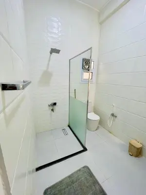 a bathroom with a glass shower and a toilet at Quiet Villa in Luxor